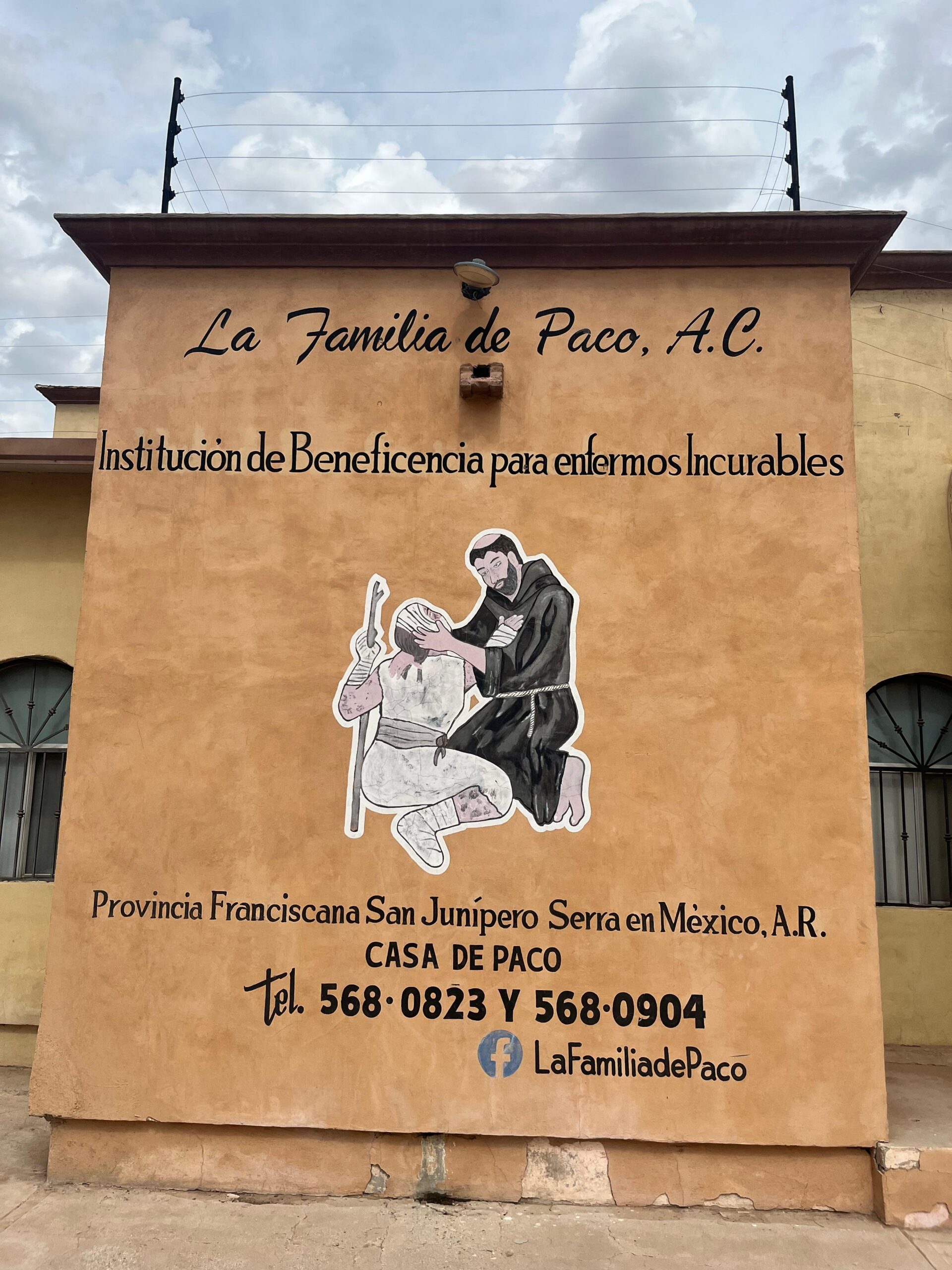 Fachada de Casa de Paco en Mexicali, con el nombre de La Familia de Paco A. C. y una representación de san Francisco de Asís con un leproso.