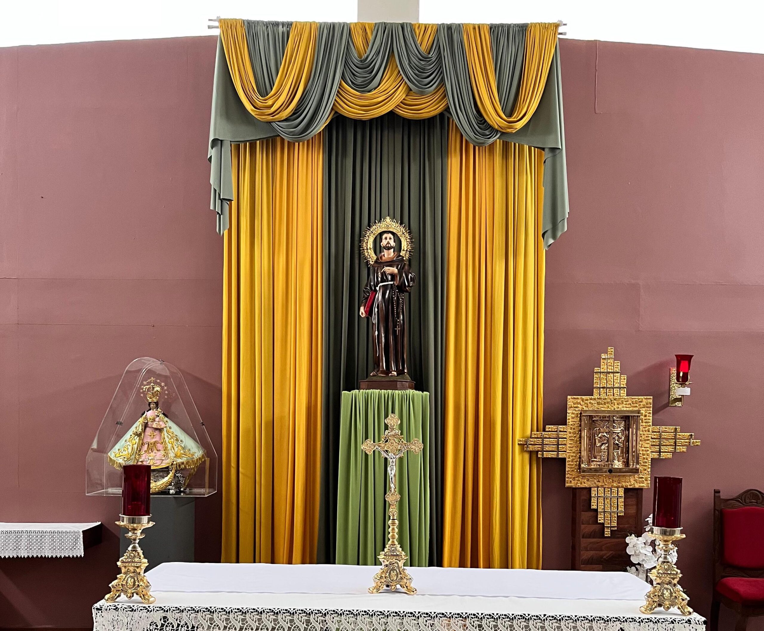Interior de la capilla de Casa de Paco en Mexicali, con altar, crucifijo, imagen de san Francisco de Asís y elementos religiosos.